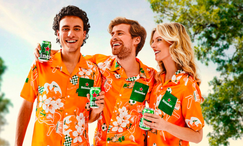 Personen in Heineken oranjehemd met bier